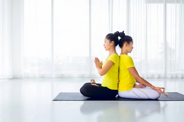 The beautiful of two Asian women are exercise yoga in the yoga room for good health and flexibility of the muscles with feel good and happiness. It is a lifestyle activity healthy for everybody.