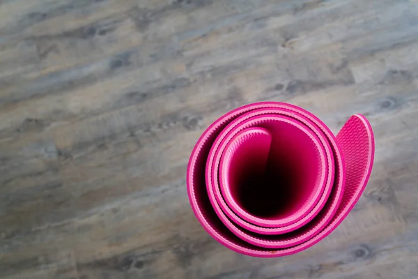 Photo of Pink yoga mat is located inside the room.