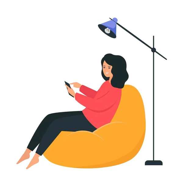 Una chica se sienta en una silla de la bolsa y sostiene un teléfono inteligente en sus manos. Feliz joven mujer charlando en Internet . — Vector de stock