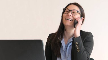 Akıllı telefonda gülümseyen Asyalı iş kadını 