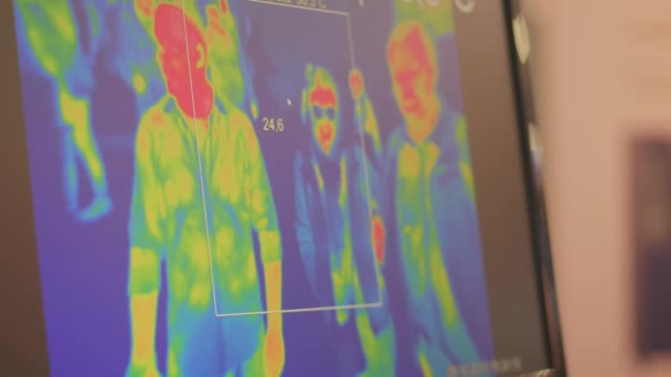 非接触赤外線温度計熱センサーカメラのディスプレイ上の人々を移動します カラーシルエットの熱センサーの画面 監視監視監視検査の概念 公共空間を撮影するCctvカメラの熱放射 — ストック動画