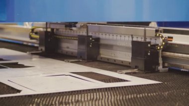 Lazer kesme makinesiyle düz ölçekli metal üretimi kesmek. Servo-elektrik yumruklama teknolojisi fabrikada malzeme ile çalışıyor. Jet kesimiyle metal işi. Modern endüstriyel kesici aracı