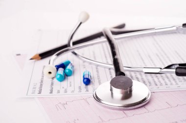 Stetoskop ve masa üzerinde haplar olan pano.