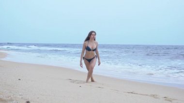 Bikinili güzel bir kız, trenlerde, sahilde, Hint Okyanusu 'nda