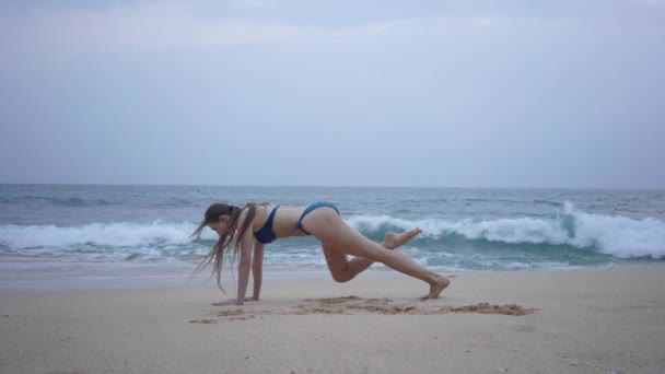 Uma menina bonita em um biquíni, trens, na praia, Oceano Índico — Vídeo de Stock