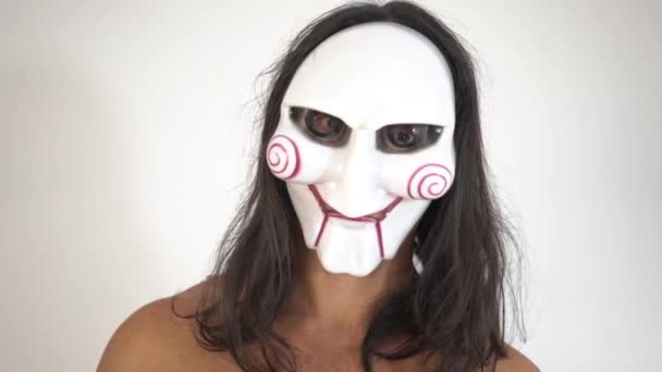 Человек в ужасной серебряной маске черепа, крупным планом, на белом фоне — стоковое видео