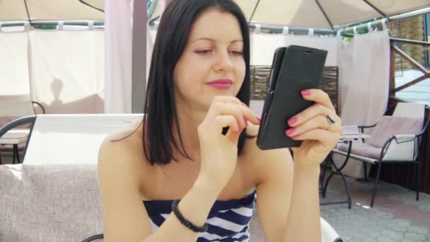 Gyönyörű nők kávéznak egy kávézóban, és nézik az okostelefont. — Stock videók