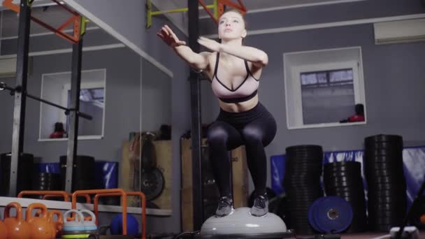 Красивая, сексуальная девушка, блондинка, тренируется на Босу, держит равновесие — стоковое видео
