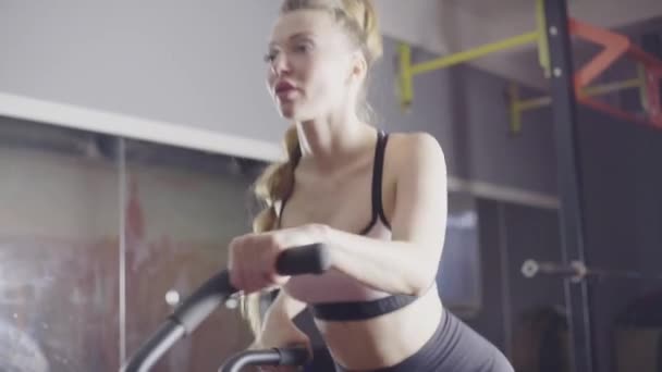 Sexy vrouwen, blond met lang haar, train op een fiets — Stockvideo