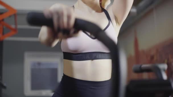 Сексуальная девушка, блондинка с длинными волосами, тренируется на велосипеде — стоковое видео