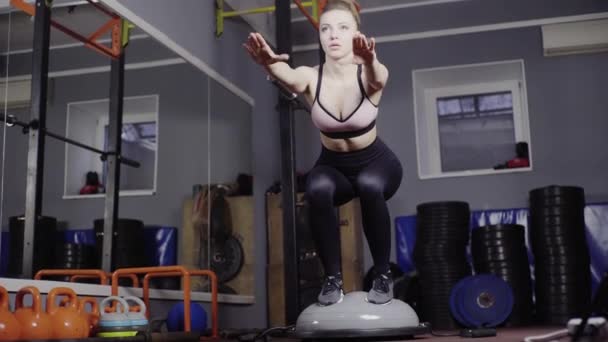 Meisje traint op balans doet hurken — Stockvideo