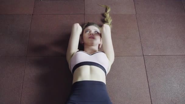Hübsches Mädchen trainiert die Muskeln des Corr, hebt die Hüften — Stockvideo