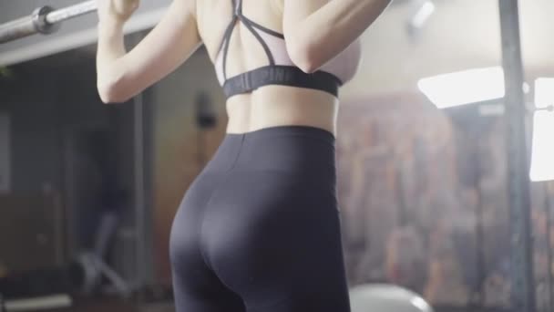 Sexy, hubená dívka, dělá náklon s činkou — Stock video