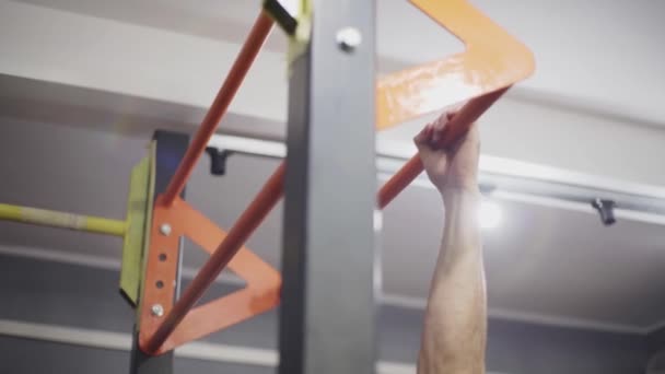 Man met lang haar maakt pull-ups op de tourniquet — Stockvideo