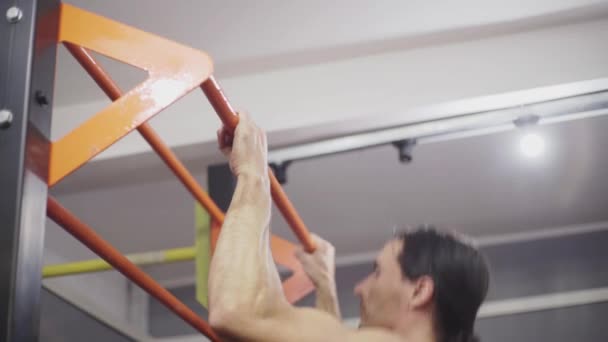 Guy with long hair makes pull-ups on the turnstile — Stock Video