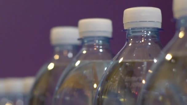 Пластиковые бутылки с водой, к серой кирпичной стене — стоковое видео