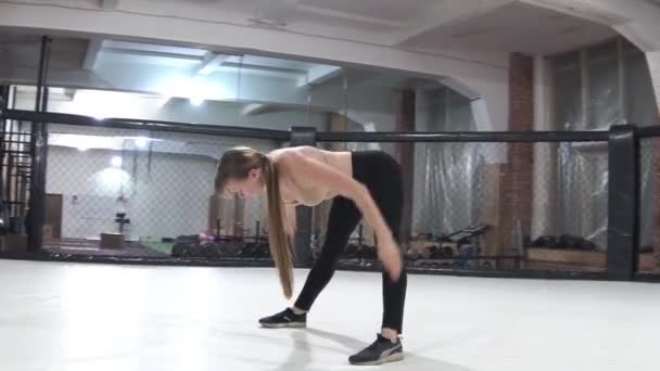 Beautiful athletic girl, warms up, stretches the muscles of the hands, makes tilts forward — Stock Video