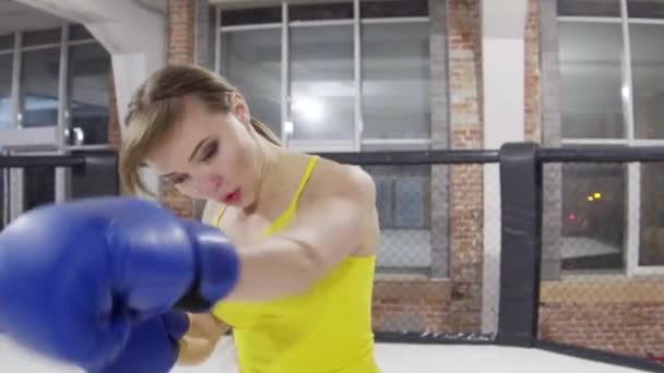 Mooi meisje, in een geel t-shirt, boxer, boksen, training in een kooi — Stockvideo