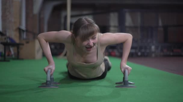 Slender woman trains, learns to do push-ups from the floor, she does not succeed, she laughs — Stock Video