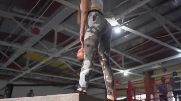 Beautiful woman, squats with weights standing on crossfit box — Stock Video