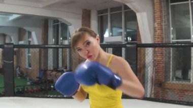 Beautiful woman, in a yellow shirt, boxing in the ring, slow-motion