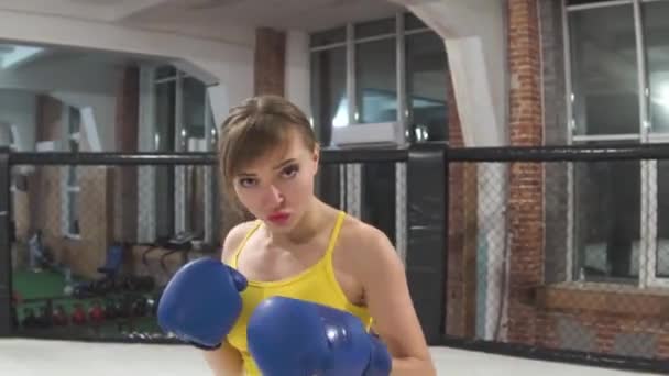 Красива жінка, спортсменка в жовтій сорочці, в боксерських рукавичках, тренування в обручці — стокове відео