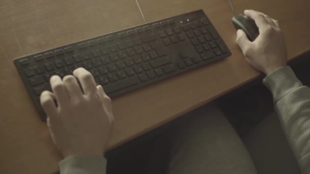 Adam bilgisayarda bilgisayar oyunu oynuyor elleri bilgisayar faresi ve klavyesinde. — Stok video