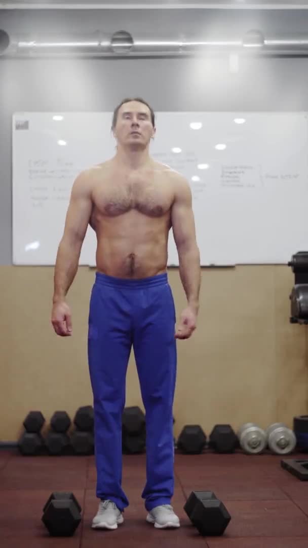 Un tipo con un hermoso torso, entrena Marco de vídeo vertical 9: 16 — Vídeos de Stock