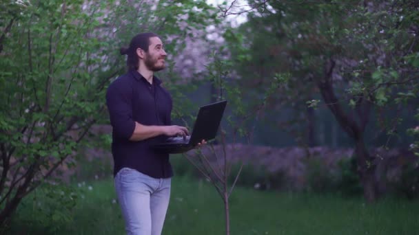 Ein Mann scherzt und amüsiert sich im Garten — Stockvideo