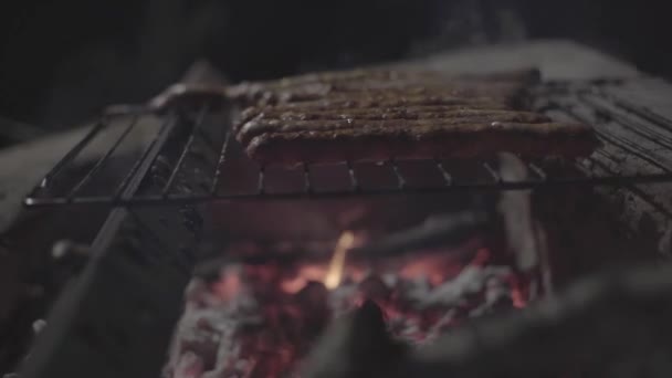 Les saucisses sont frites sur le feu le soir dans la cour — Video