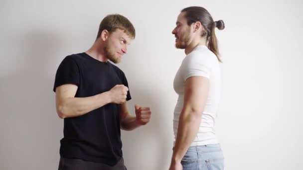 Mannen, modellen zijn grappen, lachen, klaar voor een shoot, op een witte achtergrond — Stockvideo