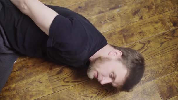 El hombre es torturado, está acostado en el suelo y se le aplica una plancha caliente en la mejilla. — Vídeos de Stock