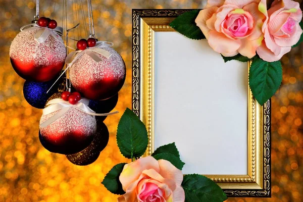 Frame of rose flowers and Christmas toy balls on romantic festive gold background of bokeh lights.    Frame for photo, picture or important text, colorful rainbow lights in a frame of rose flowers, Christmas and new year decoration.