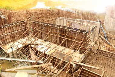 İnşaat işçileri bariyeri inşa ediyor ve suyu engelliyor. Yaklaşan yağmur mevsiminde doğal afetlerden önce babadan akması gereken yol. Bir baraj inşa etmek.