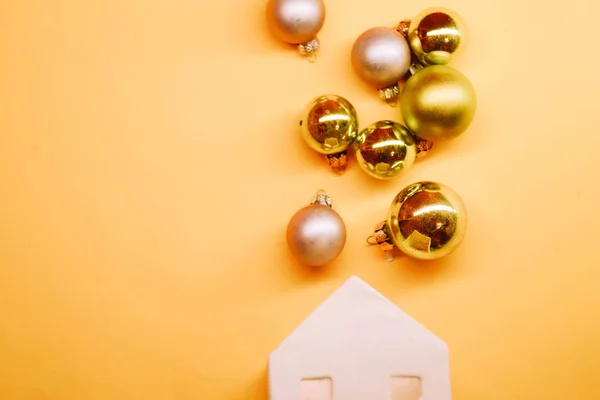 Weißes Spielzeughaus Mit Goldenen Weihnachtskugeln Pastell Üppigen Lava Hintergrund Kopierraum — Stockfoto