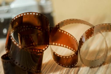 35 mm 'lik film kaseti arka planı bulanıklaştırdı. Ahşap dokuma. Film fotoğrafçılığı konsepti. Film geliştirme. Yaratıcı klasik hobi. Film amatörü. Aile arşivi