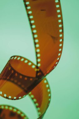 Turkuaz arka planda 35 mm 'lik bir bant. Film fotoğrafçılığı konsepti. Film geliştirme. Yaratıcı hobi. Film fotoğrafçısı.