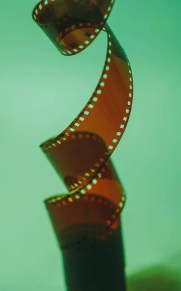 35 mm film tape on turquoise background. Film photography concept. Film development. Creative hobby. Film photo amateur