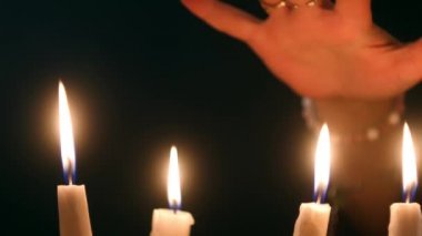 Mumların altındaki eski kitaptan bir cadı büyüsü. Falcı ruhları çağırıyor. Cadılar Bayramı konsepti Gizemli video 4K. Esrarengiz ve gizemli bir atmosfer.