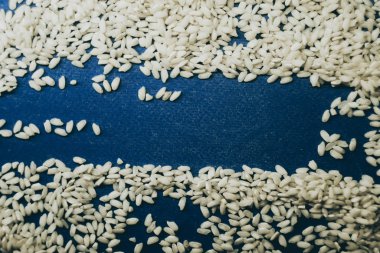 Mavi arka planda pirinç taneleri. Asya gıda kavramı 