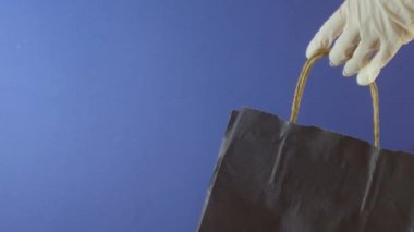 Lastik eldivenler, alışveriş torbası. Paket teslimatı. Virüs koruması. İnternetten alışveriş. Salgın Sevkiyat 