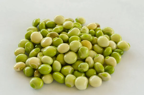 绿色和白色的鸽子豌豆颗粒被聚集在一个白色的表面上 — 图库照片