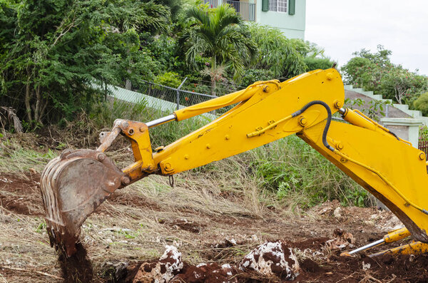 As the dipper stick of the backhoe rises from the ground the bucket tilts over dumping out its earth content.
