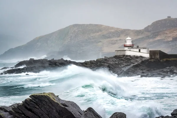 Stormy seas and high waves crashing on the rocks in front of Valentia Lighthouse in County Kerry Ireland