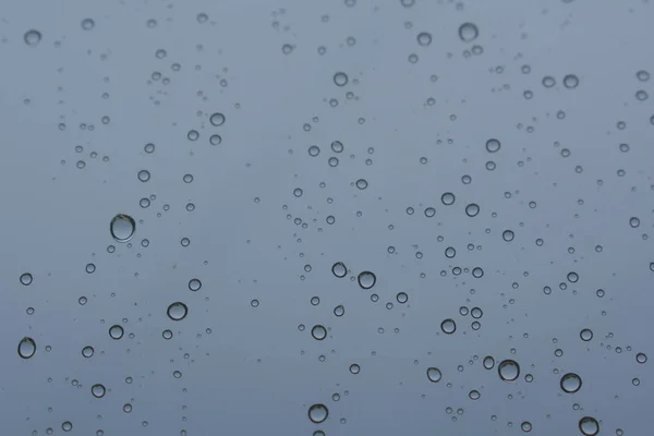 Raindrops on glass in cloudy summer weather — Stock Photo, Image