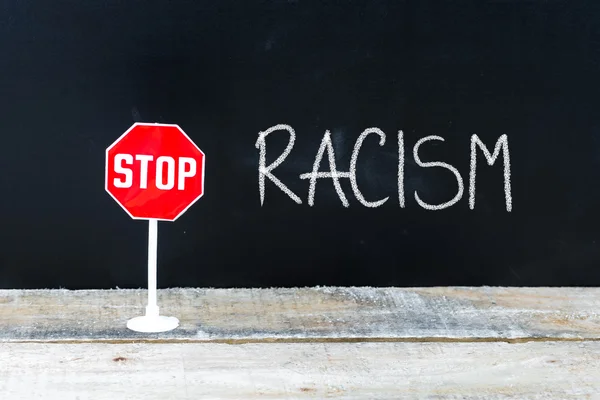 Сообщение STOP RACISM написано на доске — стоковое фото