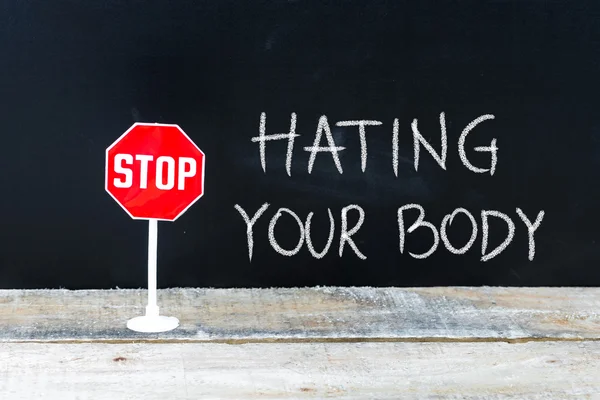 Прекратите ненавидеть свое тело сообщение написано на доске — стоковое фото