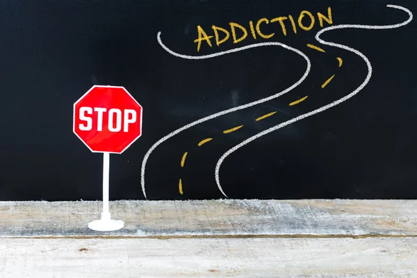 Mini STOP sign on the road to ADDICTION — Stock Photo, Image