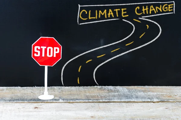 Mini STOP sign on the road to CLIMATE CHANGE — Stock Photo, Image