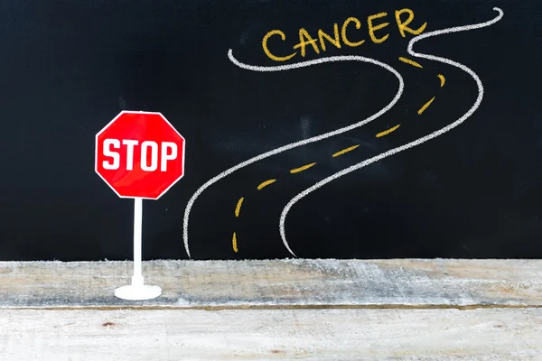 Mini STOP sign on the road to CANCER — Stock Photo, Image